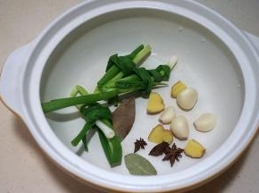 小葱打结，姜切厚片，八角、香叶、大蒜入锅中
