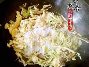 倒入粉丝和鸡蛋，加盐，生抽，老抽，鸡精，少许醋，翻炒