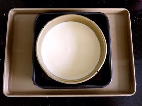 把装好面糊的模具放到一个8寸模具中。再把两个模具放到装好水的烤盘中。