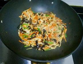 放入青椒，木耳，茭白，翻炒均匀，倒入调料汁翻炒至熟