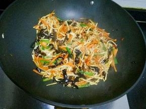 放入青椒，木耳，茭白，翻炒均匀，倒入调料汁翻炒至熟