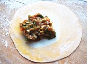 取适量馅料放在面片靠一端的位置。