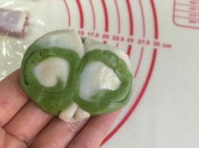 取一份松弛好酥皮，用手指中间压下，两边向中间对折。