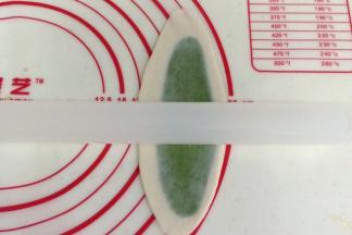 取一份油酥皮，用擀面杖擀成长舌状。