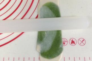 松弛好的酥皮再次用擀面杖擀长。