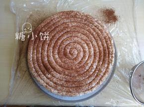 把打发的淡奶油以圈形挤在表面（如图），再撒上可可粉装饰即可