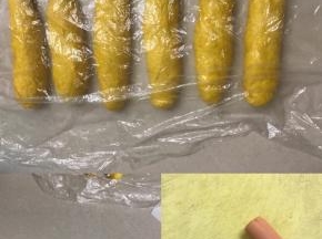 7 轻拍面团排气分成六份，拉长搓圆，盖上保鲜膜松弛15 分钟
8 用二手掌来回搓长大约55 公分长
9 把火腿肠一切二，从中间斜切一刀