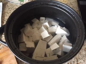 豆腐，切成块，放入煮锅中；加入适量水，备用；