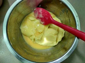 将120克鸡蛋液分3次加入面糊，每加一次，用刮刀不停搅拌面糊，等面糊完全吸收蛋液后再加下一次。