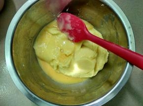 将120克鸡蛋液分3次加入面糊，每加一次，用刮刀不停搅拌面糊，等面糊完全吸收蛋液后再加下一次。