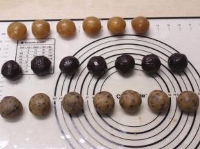 取一个馅料压扁，中间放入半个咸蛋黄，收口揉圆备用