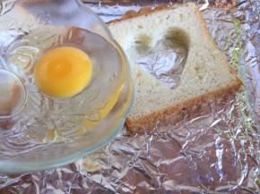 然后，再在吐司的爱心里，打入鸡蛋；