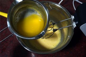 隔水融化黄油，然后加入到蛋黄糊中，加入1克食盐，拌均匀。