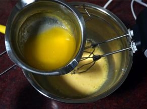 隔水融化黄油，然后加入到蛋黄糊中，加入1克食盐，拌均匀。