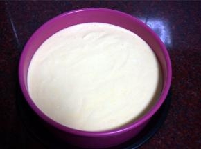 8寸模具底部垫上一张8寸的圆形吸油纸（若没有，请忽略），刷上一层薄薄的烤盘油，然后倒入蛋糕糊，震荡出大气泡。