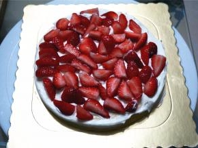 将最底的那片蛋糕片放在底托上，抹上一层淡奶油，然后铺放上草莓粒，多放点水果可以少填些奶油，吃起来更清爽不腻。
13、