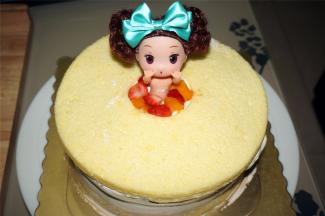 将最后一片中间掏空了的蛋糕片铺放到最表层，然后插入公主娃娃，四周用水果粒填充逼实。
15、