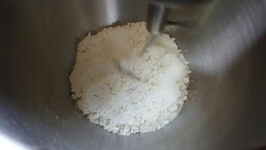 1．将麻薯预拌粉、高筋面粉、盐、糖混合在厨师机桶内，慢速搅拌均匀。