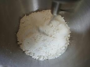 1．将麻薯预拌粉、高筋面粉、盐、糖混合在厨师机桶内，慢速搅拌均匀。
