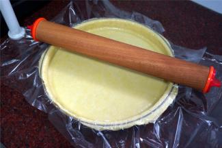 用手轻轻按压派盘边至服贴，并用擀面杖擀去多余的派皮。