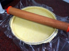 用手轻轻按压派盘边至服贴，并用擀面杖擀去多余的派皮。