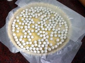 在派皮上垫油纸，放入小圆石，防止烘烤时鼓起。烤箱上下火170度，约烤20分钟取出备用。