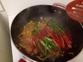 这时候先把辣椒油倒入，来热锅，再入洋葱和葱头炒到变软，再加入青辣椒和红辣椒炒一下，这时候离火，再倒入酱汁，这时候酱汁会变的很浓稠，没有关系，再把鸡块放入，锅放到火上再搅拌一下酱汁和鸡块均匀就可以吃咯。