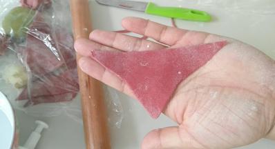 红面团，擀成片，用刀切出三角形。