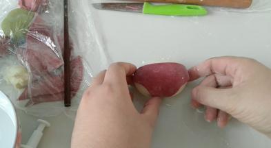 红面团背部沾些水，贴上去。