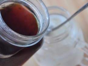 用勺背抵在杯口，将咖啡液缓缓从勺背倒入杯中。