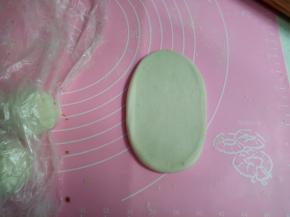 用擀面杖擀成5-6CM大小的面，从中间往上一下，往下一下，一上一下，平均轻轻，能拉长点就长点。再从上面往下卷起来，收口向上。