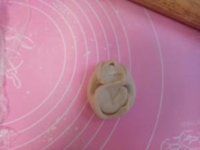 松弛好的油酥皮，封口朝上，拇指由中间按下，然后四角朝中间折叠，用擀面杖轻轻擀压薄