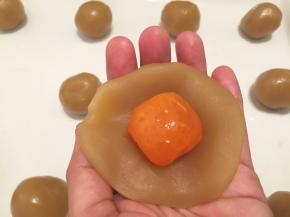 等蛋黄放凉后，将蛋黄包入莲蓉后搓圆