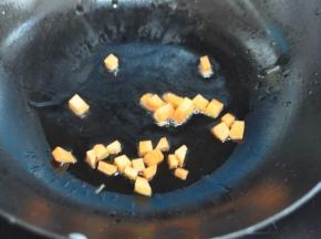 锅里倒入油，放入胡萝卜丁。