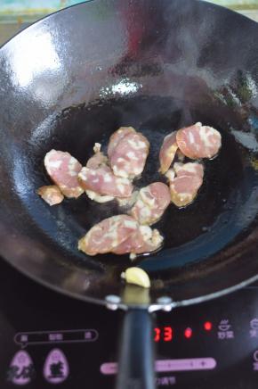 锅里倒入油，放入蒜炸香，放入腊肠炒香。
