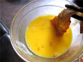 取腌制好的虾仁沾上蛋液