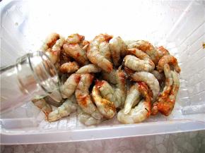 将所有的虾切好后放入容器内，用料酒、盐腌制入味。