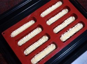 将面糊装入裱花袋，花嘴用的是10齿菊花嘴。将面糊挤到8连长条形硅胶模具中（模具放在烤盘上），放入预热好的烤箱中层上火180度，下火160度烘烤20分钟，余温焖5分钟至表面金黄即可取出，脱模冷却。