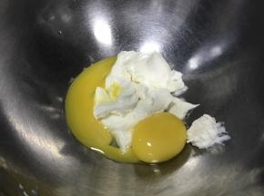 加入蛋黄，搅打均匀。我是自己做的奶油奶酪，很容易打顺滑，所以直接加蛋黄。