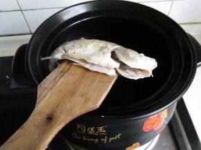 砂锅里的水已经开了，把煎好的鲈鱼和大蒜一起放入。