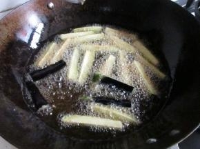 锅里放油烧热，下入茄子炸制。