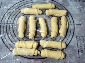 逐一擀开排气，卷起，盖上保鲜膜松弛15分钟。