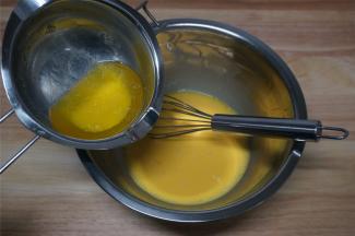 将液态黄油加入到蛋黄中，搅打至融合。