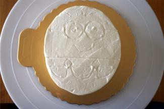 将蛋糕体移放到蛋糕底托上，整体抹上一层打发了的淡奶油。然后用牙签画出小黄人的图案。