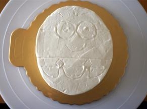 将蛋糕体移放到蛋糕底托上，整体抹上一层打发了的淡奶油。然后用牙签画出小黄人的图案。