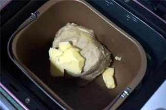 将主料中黄油除外的食材，按照先液体后固体的顺序放入面包机内，启动一个揉面程序，时间20分钟。程序结束后放入24克黄油块，再次启动一个揉面程序20分钟，面团能拉出薄膜即可。