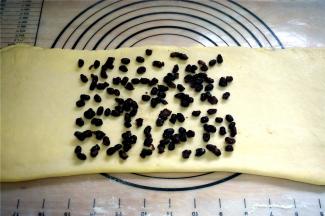 将包裹着黄油的面片擀成长条形，在中间三分之二处放入适量的蜜红豆，然后盖上左端的三分之一面片，再在其上撒上适量的蜜红豆，最后盖上右端三分之一的面片。将折叠好的面片放入冰箱冷冻10分钟。