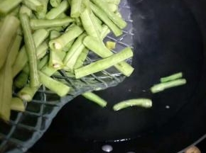 取一干净的锅，倒入清水，待水烧开后倒入豇豆；