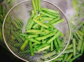 大火烧开后，豇豆颜色变得翠绿，转小火一分钟即可关火；