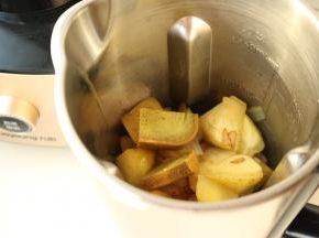把煎过的土豆块、洋葱块、培根以及咖喱放入破壁调理机的不锈钢搅拌杯内。